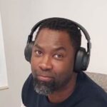 Smiling man wearing headphones in a casual office